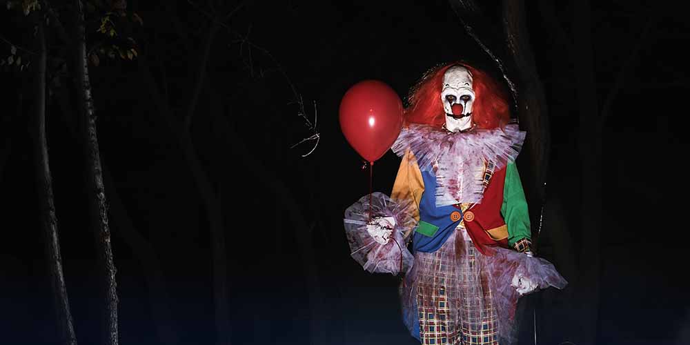 creepy clown holding haunted balloon