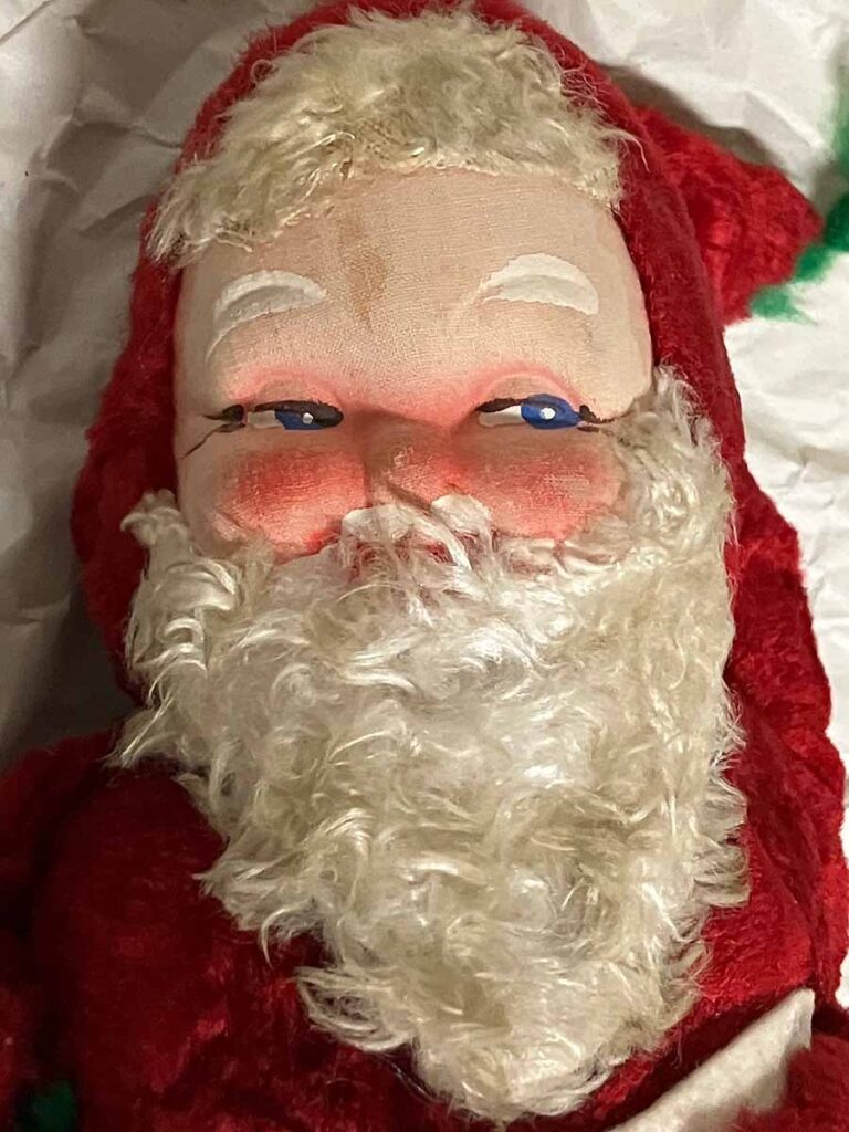 A closeup of the face of scary Christmas doll of Santa