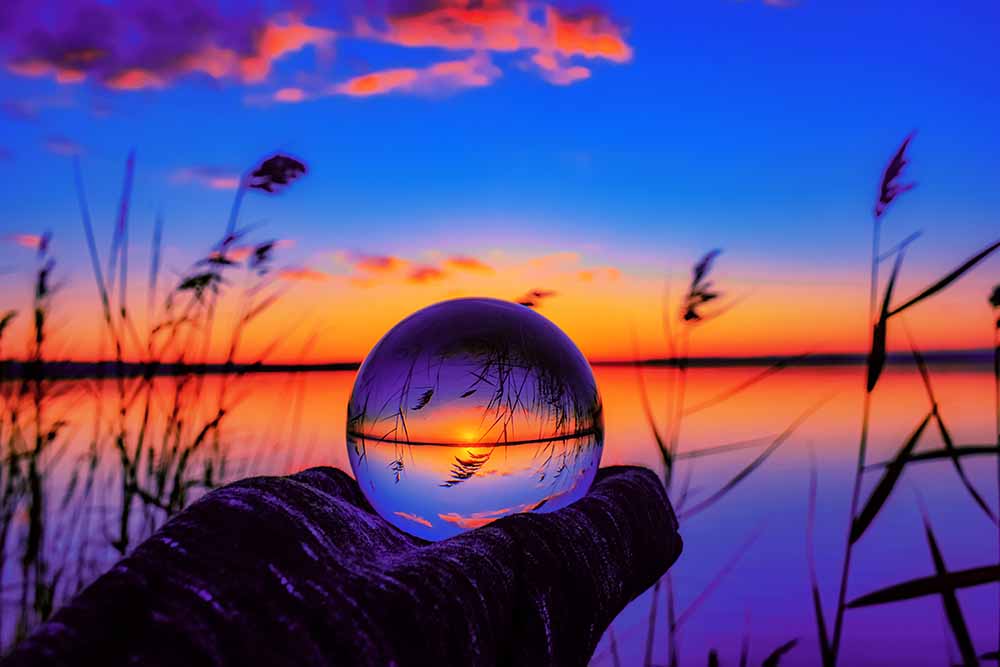 crystal ball against still water at sunset