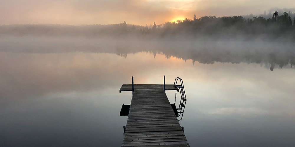 premonitions of death: a dock on a lake in a misty atmosphere