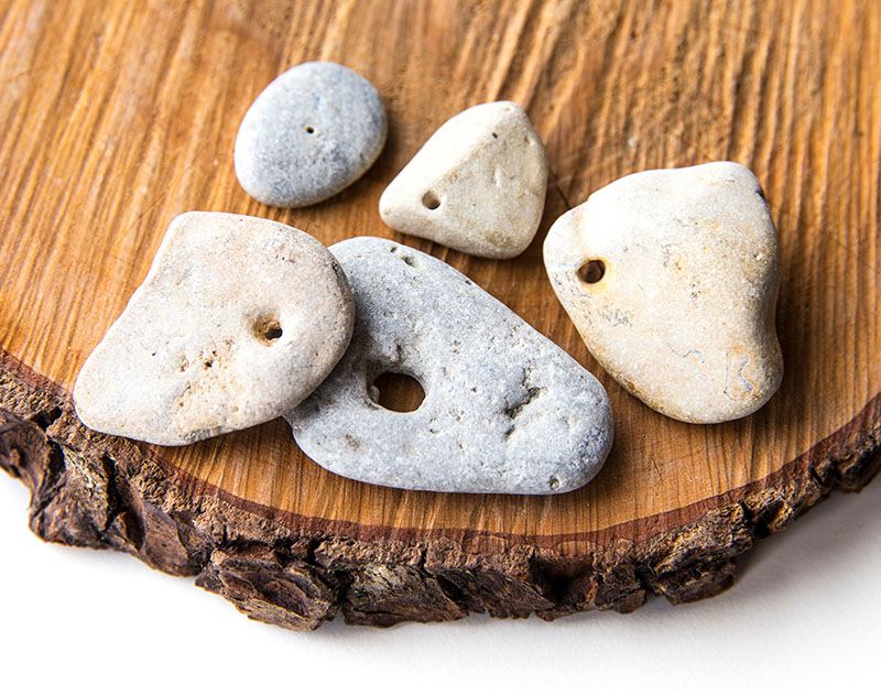 smooth river stones with holes worn through them, also known as hagstones in Celtic tradition. 