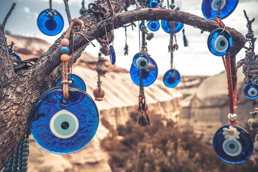 A grouping of Nazars--talismans that look like round dark blue disks with smaller light blue eyes painted on them--hang from a tree in Turkey as a way to ward off the Evil Eye.