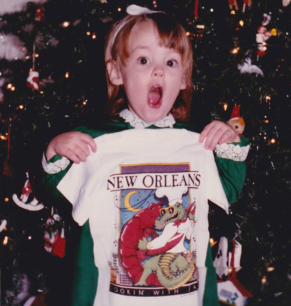 Diana around age 3, receiving a New Orleans t shirt for Christmas and getting very excited about it.