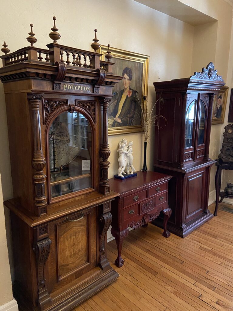 Antique Polyphon music box displayed in the lobby of Lake Lure Inn, featuring intricate wood carvings and traditional Victorian architecture