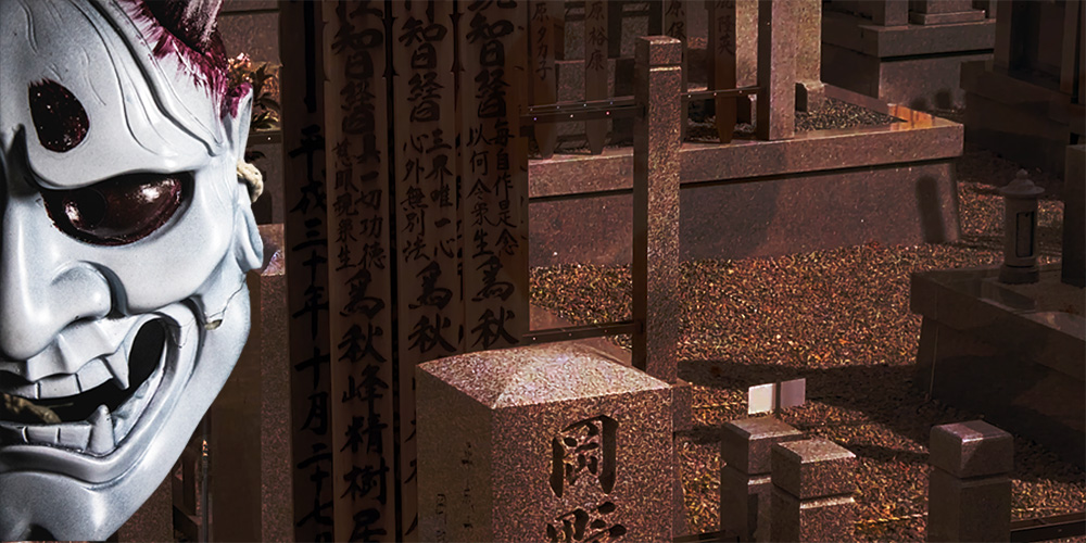 an Oni mask in front of a Japanese cemetery